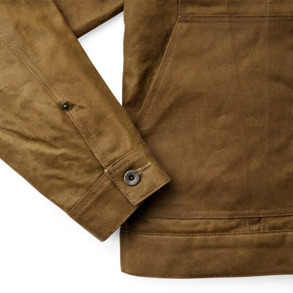 Close-up of the waxed cotton texture and metal button hardware.