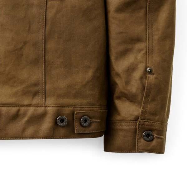 Close-up of the waxed cotton texture and metal button hardware.
